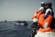 SOS Mediterranee rescuers hold life jackets as migrants on a