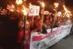 People participate in a torchlight procession to protest aga