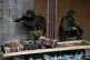 An Israeli soldier aims his weapon at Palestinian demonstrat