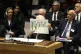 Palestinian President Mahmoud Abbas holds up a document as h