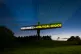 A light shines on The Angel of the North, highlighting the p