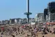 The Brighton i360 rises as people enjoy the warm weather on 
