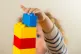 A preschool age child playing with plastic building blocks, 