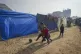 Children play football at a tent camp for displaced Palestin
