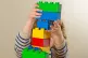 A preschool age child playing with plastic building block