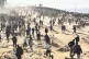 Palestinians wait for humanitarian aid on a beachfront in Ga