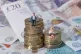 Models of a man and woman stand on a pile of coins and bank 