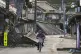 A woman cycles past damaged houses in Noto town in the Noto 