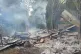 Smoke rises from debris and corrugated roofing of a school s