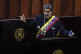 Venezuelan President Nicolas Maduro holds a small copy of hi