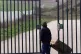 A young asylum seeker stands at the gates of the Sangatte ho