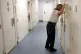 A Detention Custody Officer looks through a cell door observ