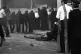 Police shelter behind riot shields as a youth is dragged awa