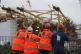 Workers look on from a viewing platform as work continues on