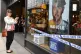A woman photographs a #spycops poster in the display window 