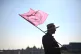 A man flies a red Extinction Rebellion flag