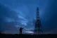 A man holds a mobile phone near the Windy Hill Transmitter o