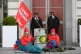 Activists lock themselves to dirty oil barrels outside BP's 