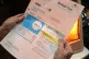An elderly woman holds a British Gas bill at her home in Liv