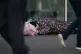 People in London walking past John, a homeless man who has b