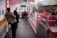 Customers maintain social distancing as they wait to collect