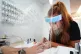 Beautician Alex Smith (26) does the nails of Jules Aspen (40