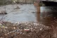 The River Calder filled with branches and rubbish flows thro