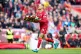 Liverpool's Jordan Henderson carries a wreath in memory of A