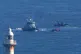 A small boat is intercepted by Border Force vessels near the