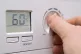 A person turns down their boiler