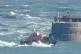 A group of people thought to be migrants are brought in to D