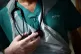 A junior doctor holding his stethoscope