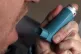 A person using an inhaler for the treatment of asthma
