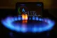 A handheld smart meter on a kitchen hob showing the cost of 