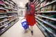 A shopper walking through the aisle of a supermarket