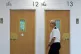 A prison officers walks passed rooms within Iris House as Ju