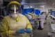 A nurse wearing PPE working on a patient in the ICU (Intensi
