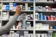  A pharmacist stocks shelves at a chemist
