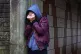 A teenage girl with her head in her hands showing signs of m