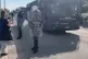 Greek cops stand by as buses are brought to transport the re