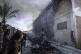 Palestinians try to extinguish a fire at a building of an UN