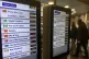 People walk by electronic boards advertising bus disruptions