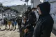 Refugees gather as riot police guard a gate in Moria camp on