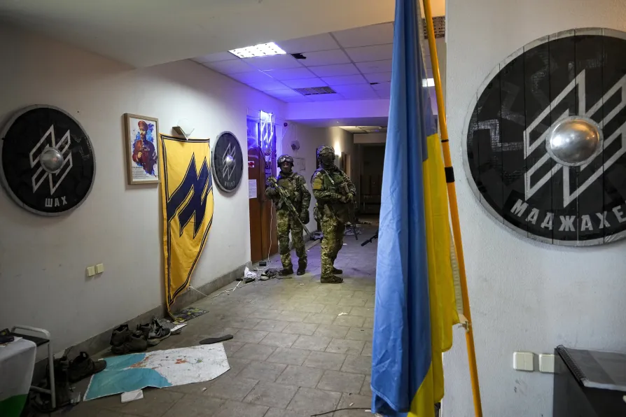 Russian soldiers walk inside Ukraine’s Azov regiment base adorned with the unit's emblems in Yuriivka resort settlement on the coast of Azov Sea not far from Mariupol, in territory under the government of the Donetsk People's Republic, eastern Ukraine, Wednesday May 18 2022